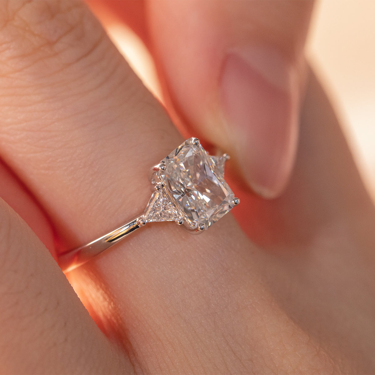 14K White Gold 1.5ct Radiant Cut Lab Diamond Three Stone Ring with Triangular Cut Lab Diamond Side Stones and Tapered Band Design